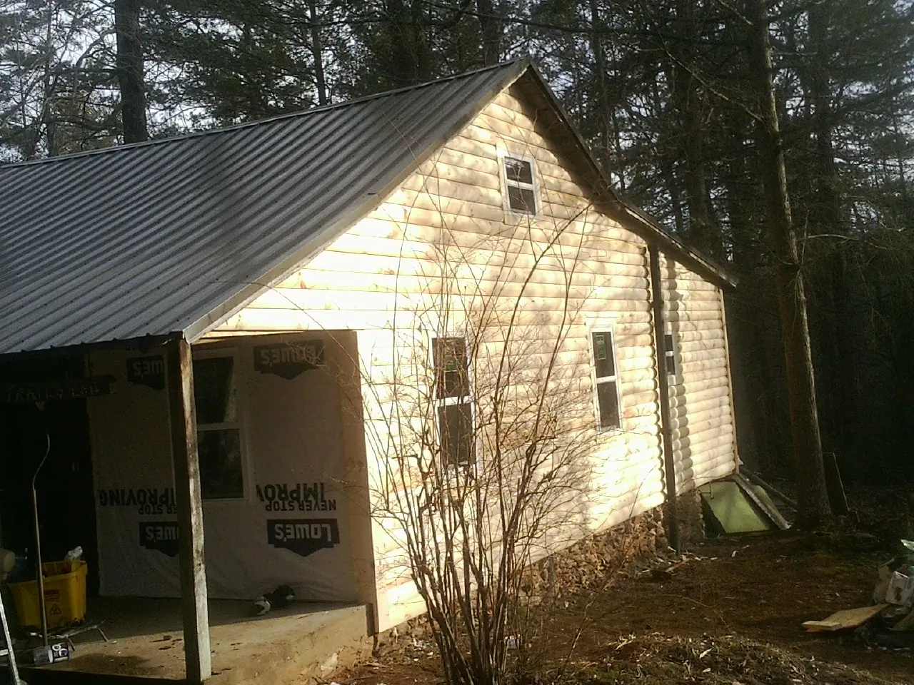 Log siding gable end under a dark metal roof edge in Moorefield