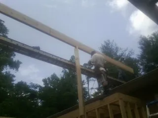 Carpenter setting a ridge beam over a new addition frame — Ice Dam Removal by Roofing Brothers in Moorefield