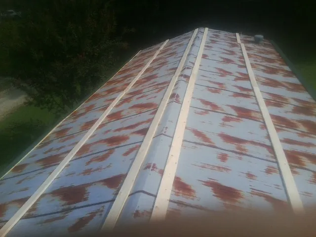 Rusted metal roof panels with new wood purlins before replacement — Storm Damage Roof Repair in Moorefield by Roofing Brothers