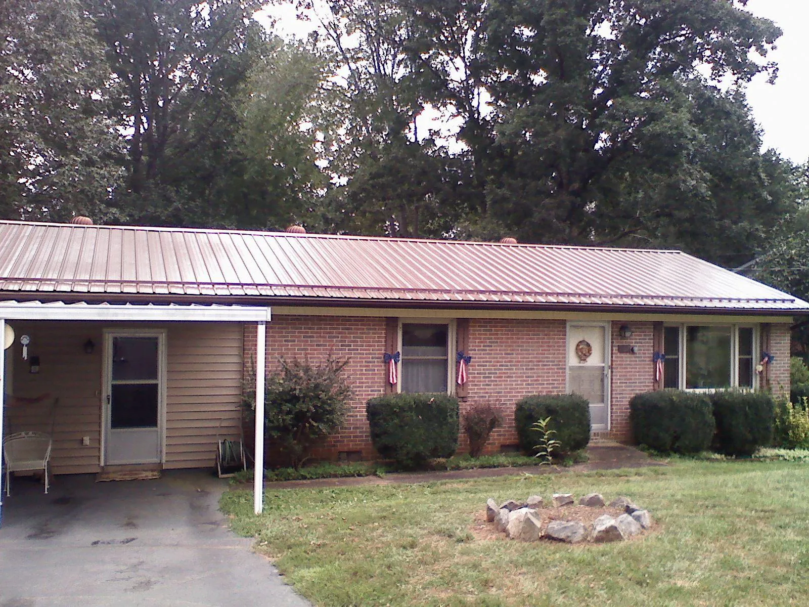 Bronze metal roof and carport on a brick ranch home — Roof Repair work by our crew in Moorefield